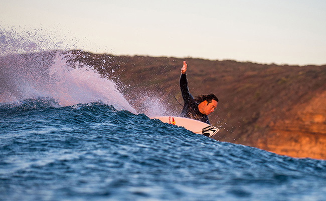 Surfer putting on an O'Neill Psycho One back-zip wetsuit