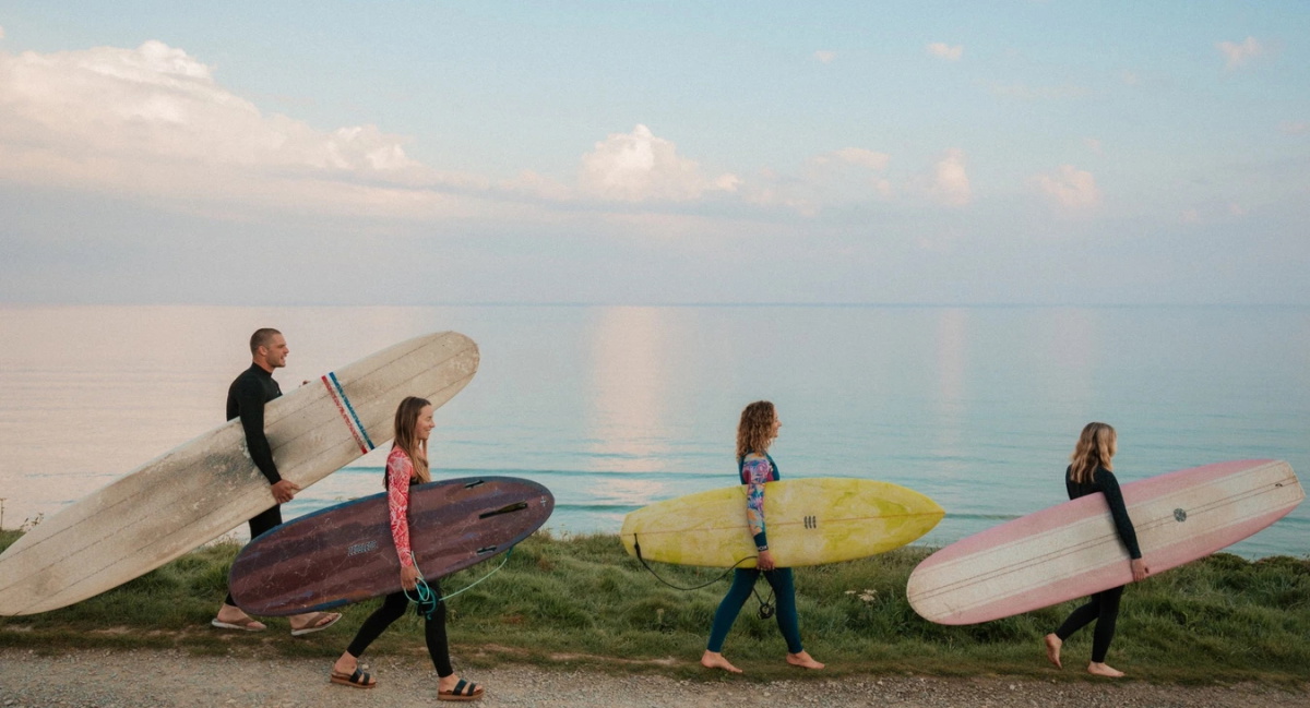 Surfer in Sommer-Neoprenanzügen auf dem Weg ins Wasser