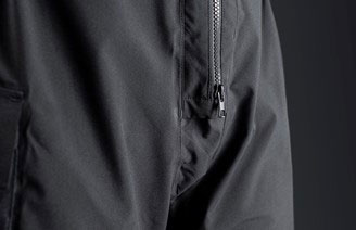Close-up of a zipped thigh pocket on dark grey technical sailing trousers