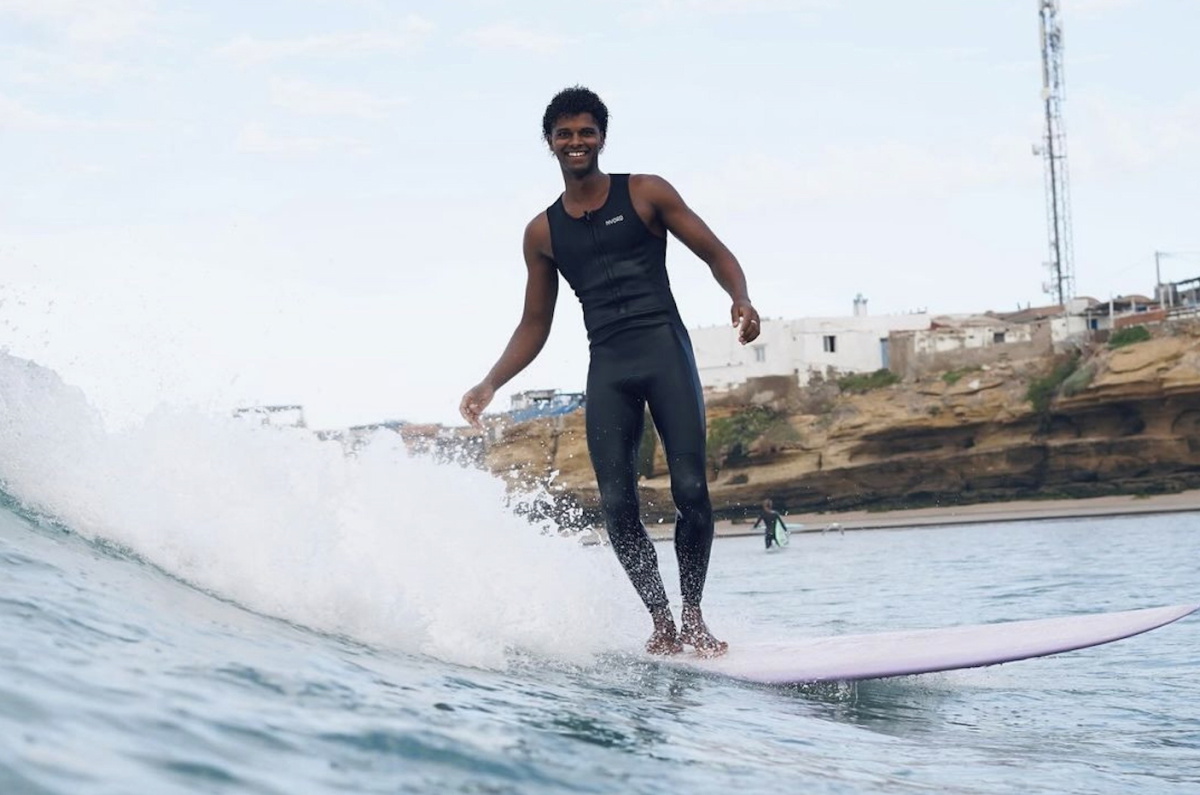 Surferin im ärmellosen Nyord Solu Long Jane Neoprenanzug am Sommerstrand